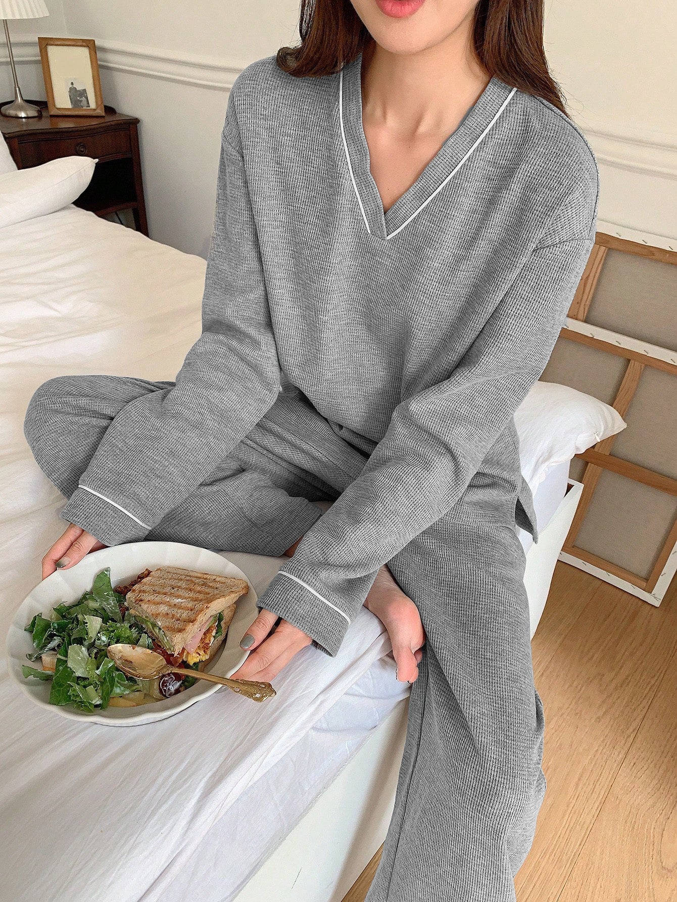 Close-up of gray ribbed pajama set detail and lunch plate with salad and sandwich