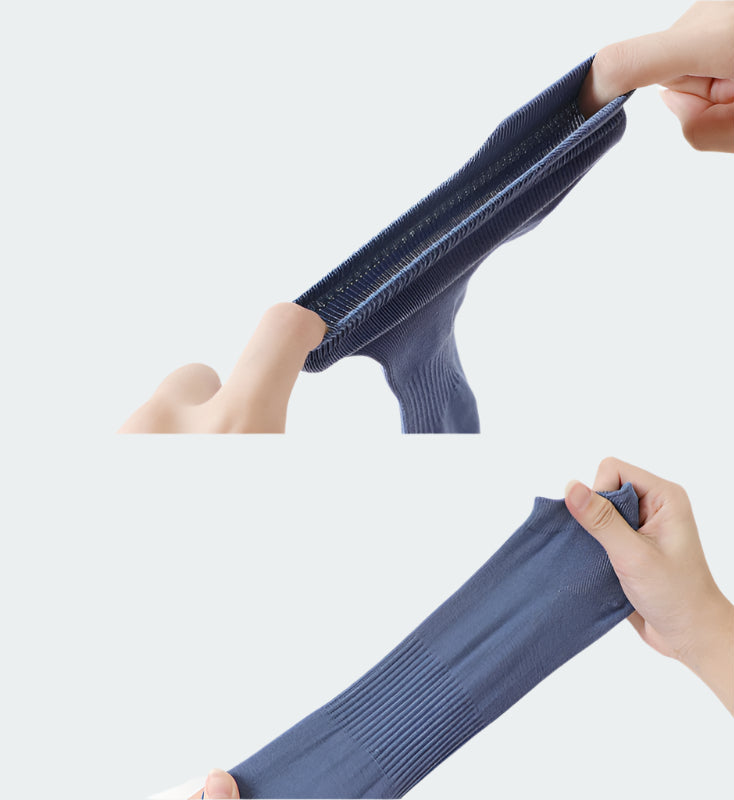 Hands demonstrating the stretch and elasticity of navy blue ankle socks against white background. Shows fabric quality with ribbed sections for comfort