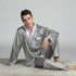 Model on white shag rug in silver pajamas with circular ring pattern and white satin trim details