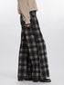 Detail view of wide-leg pants in gray and black plaid pattern