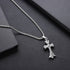 Box chain necklace with decorative cross pendant on dark leather surface