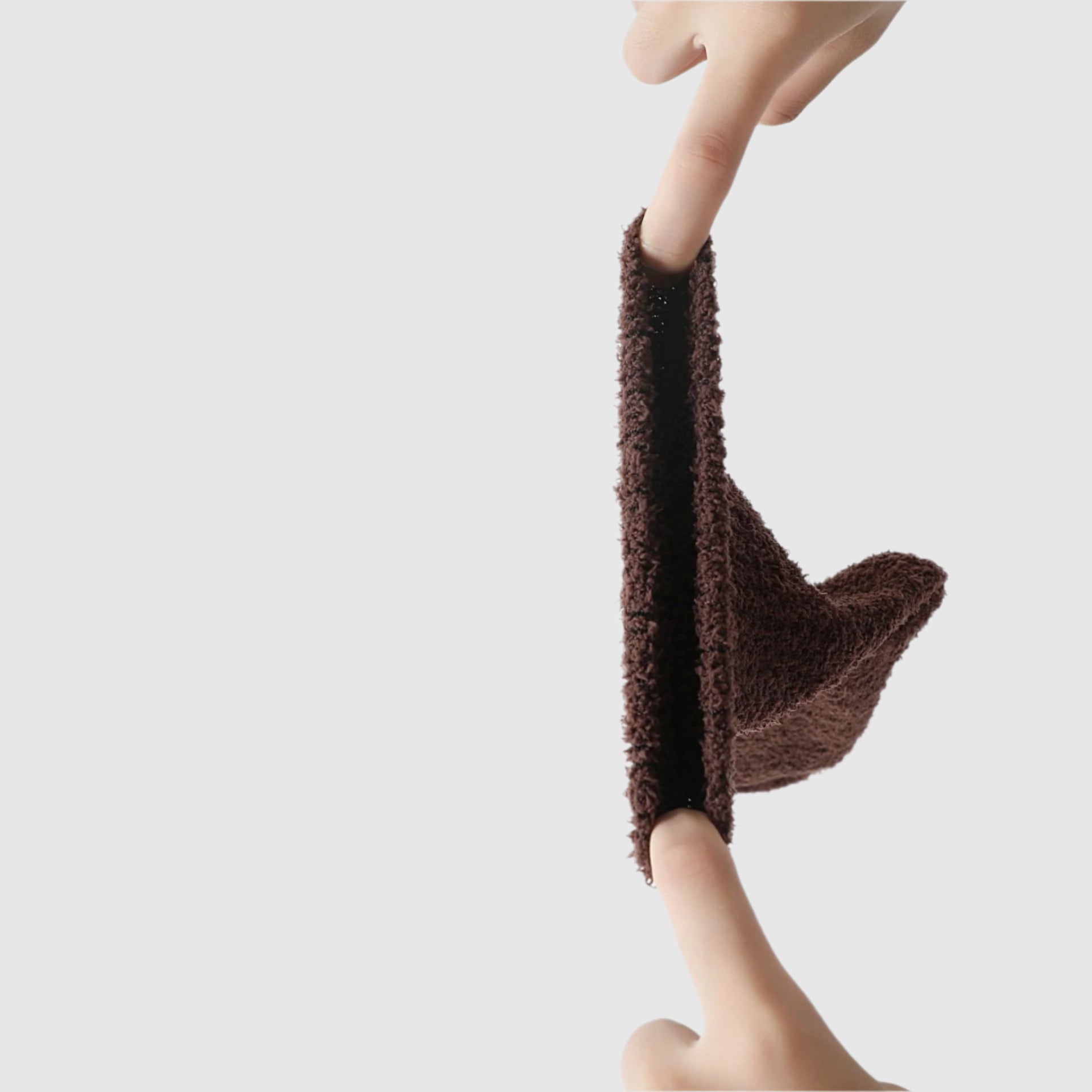 Close-up of a brown fuzzy sock being stretched, demonstrating its soft, textured knit material