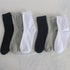 Multiple cotton crew socks in black, white, and gray arranged side by side, showing color range