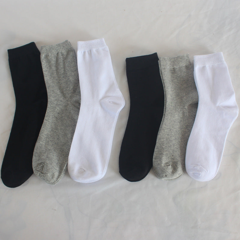 Multiple cotton crew socks in black, white, and gray arranged side by side, showing color range