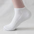 White ankle sock on mannequin foot – A close-up of a white ribbed ankle sock worn on a mannequin foot, showing the snug fit and reinforced heel