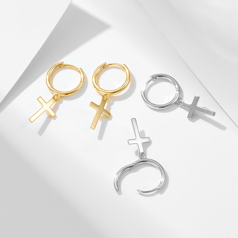 Gold and silver cross drop hoop earrings displayed on white geometric surface, showing both color options and clasp details