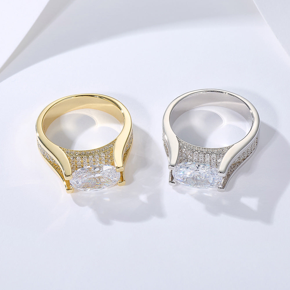 Gold and silver engagement rings with oval-cut diamonds and pave band settings displayed side by side on white surface