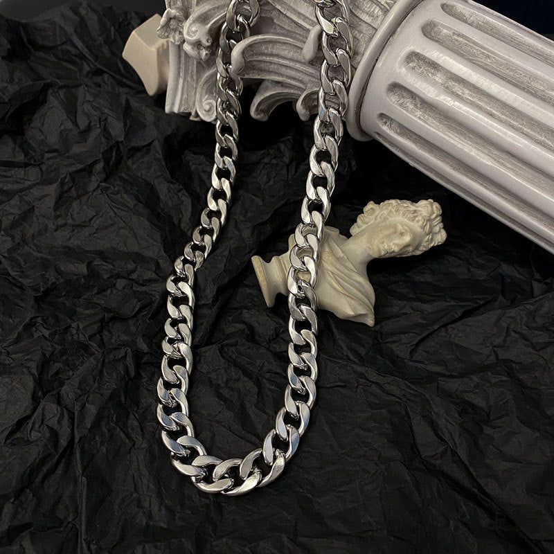 Silver curb chain necklace displayed with classical bust decorations