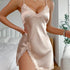 A model wearing champagne satin slip dress with lace trim and side slit, posing in bedroom setting with white bedding