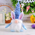 Blue sequin-hat bunny gnome plush toy with long ears and white beard, displayed on a decorative table.