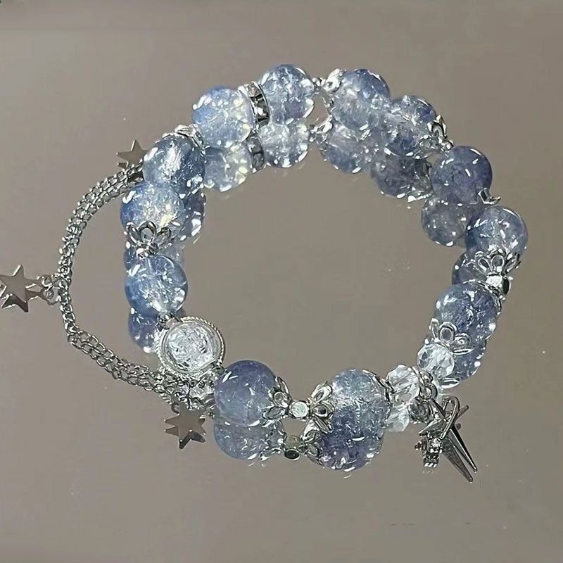 Light blue crystal beaded bracelet with silver star charms and cross pendant, featuring decorative spacers