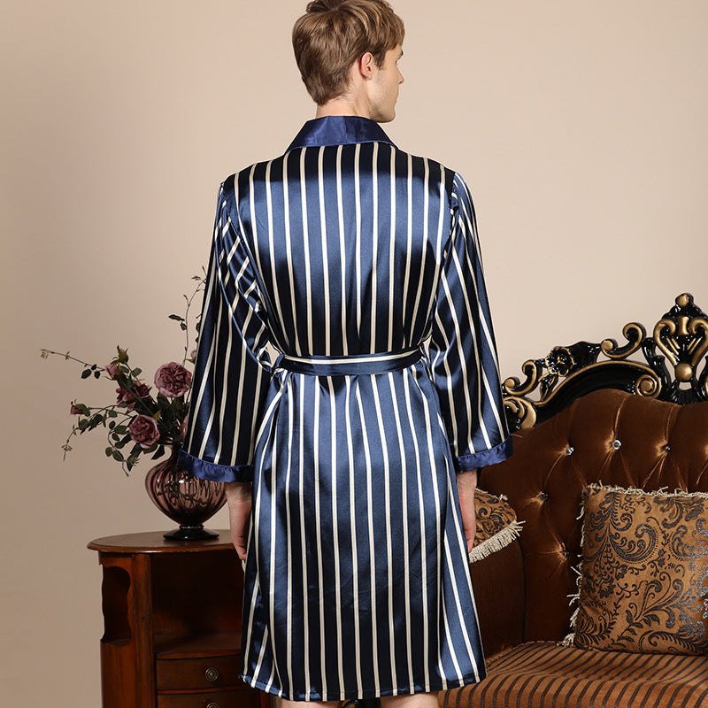 Back view of man in navy striped silk robe with satin trim. Close-up shows belted waist detail and elegant drape against vintage furniture background