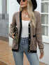 Beige cardigan with black trim and gold buttons, worn with white tank top and chain accessories