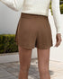 Back view of a brown mini skort showing the shorts underneath, styled with a white sweater.