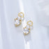 Gold diamond drop charms with double crystal stones in prong settings, displayed on white background with soft shadows