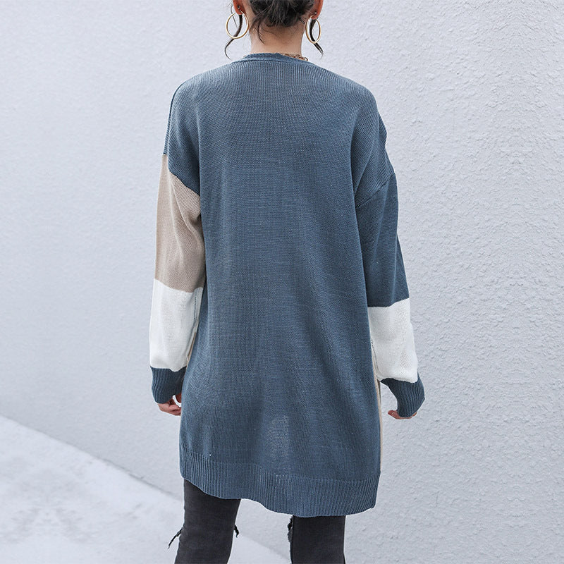 Back view of long colorblock cardigan showing slate blue body with beige and white striped sleeves