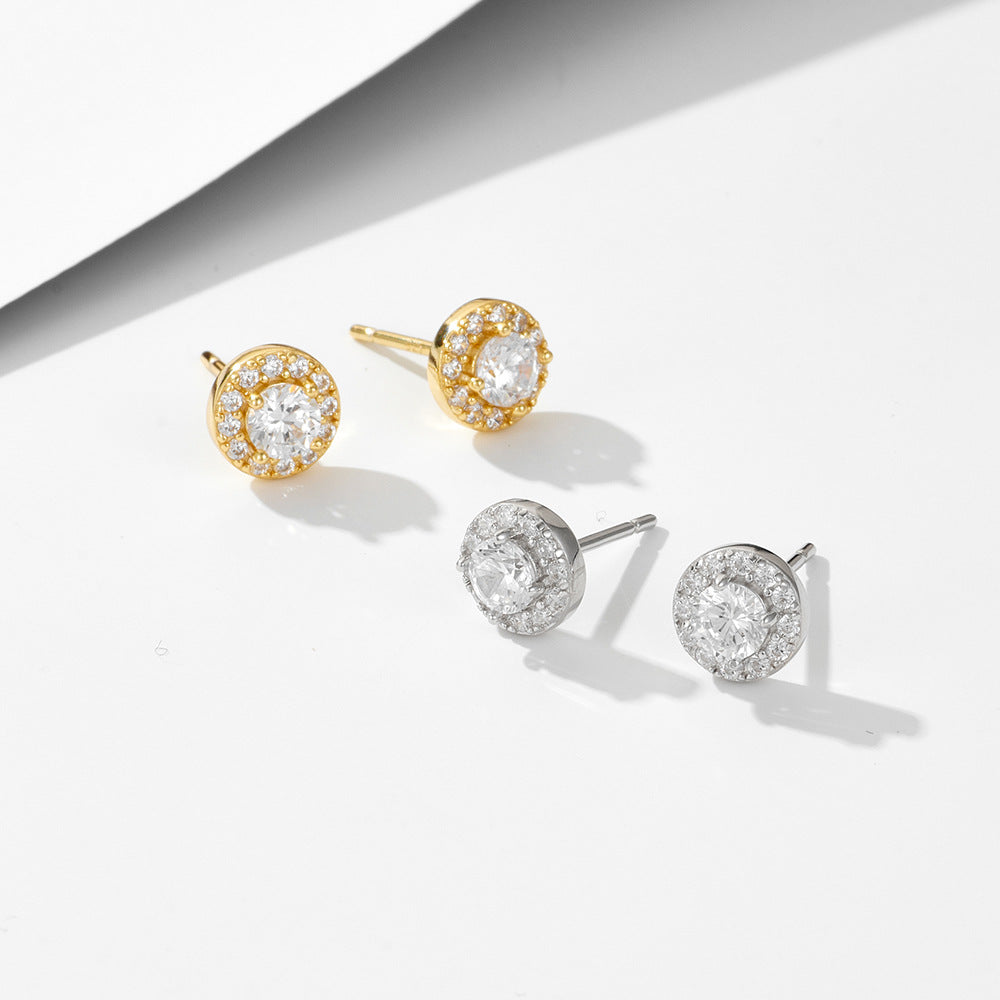 Two pairs of halo stud earrings displayed together - gold version above and silver version below - with center diamonds and pavé surrounds