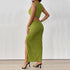 A back view of a woman wearing a green ribbed two-piece outfit, displaying the sleeveless crop top and high-waisted slit skirt from behind.