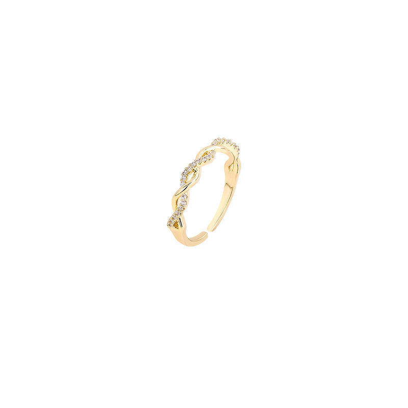 Product photo of gold adjustable ring with twisted crystal pattern on white background
