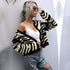 Zebra print cardigan, white crop top, ripped jeans, side pose