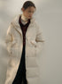 Cream colored quilted puffer coat with burgundy button-up and turtleneck layering, moody editorial styling