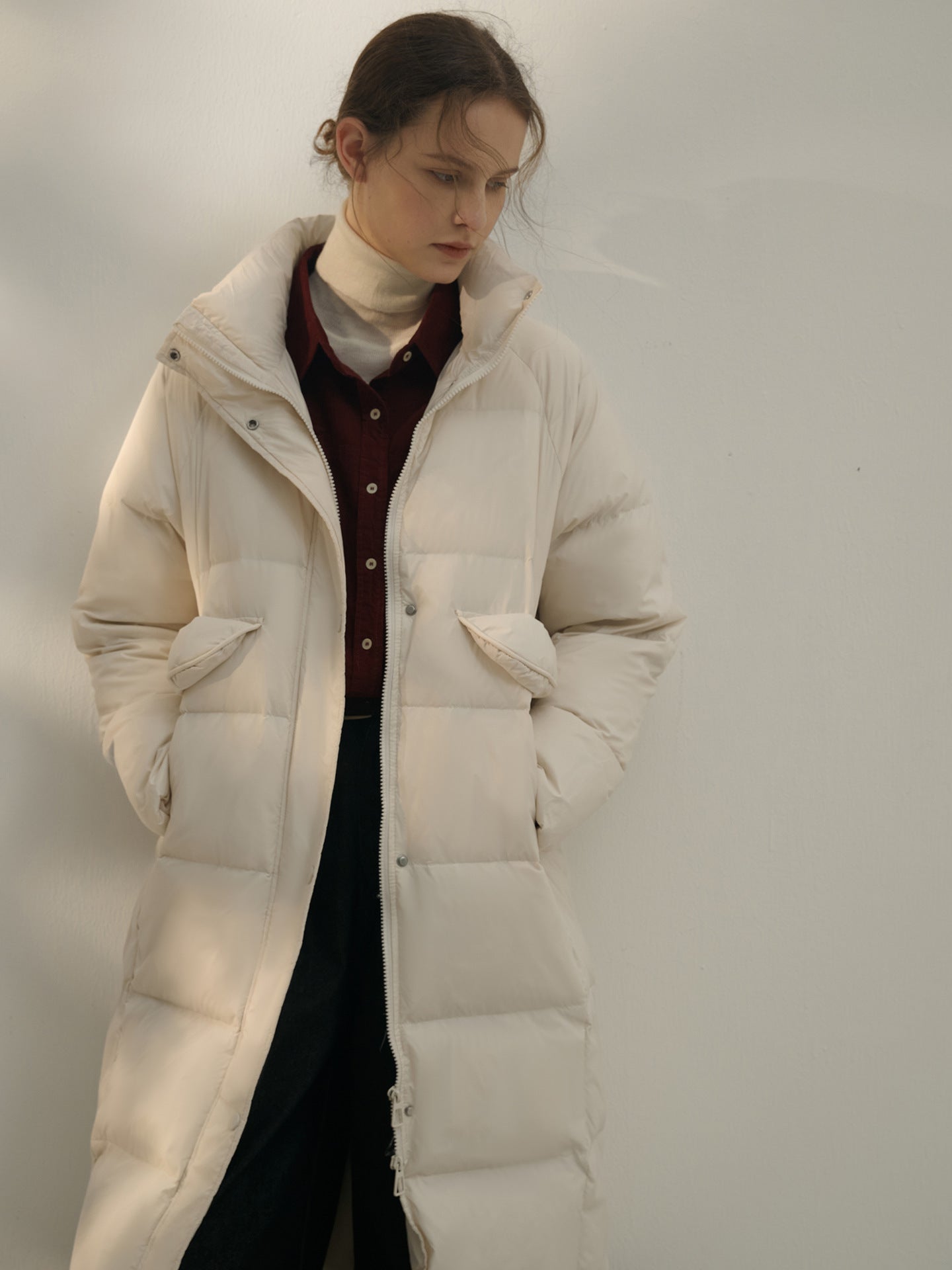 Cream colored quilted puffer coat with burgundy button-up and turtleneck layering, moody editorial styling