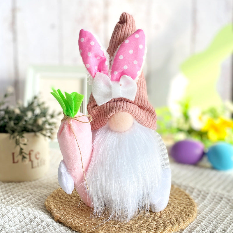 Easter gnome with a pink polka dot hat, white bunny ears, a big bow, white beard, and holding a soft pink carrot, on a round mat.