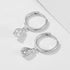 Silver 925 huggie hoops with teardrop crystal pendants displayed side by side on white background