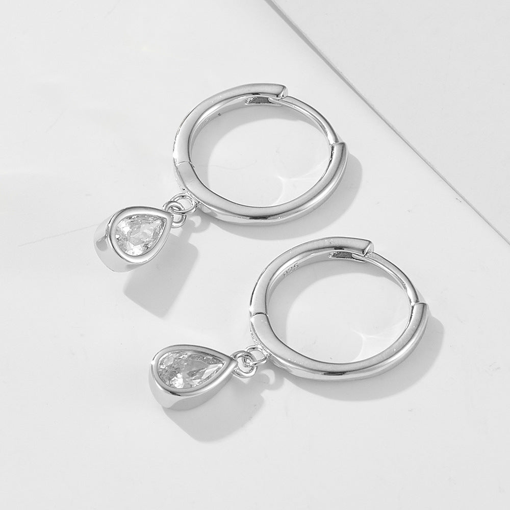 Silver 925 huggie hoops with teardrop crystal pendants displayed side by side on white background