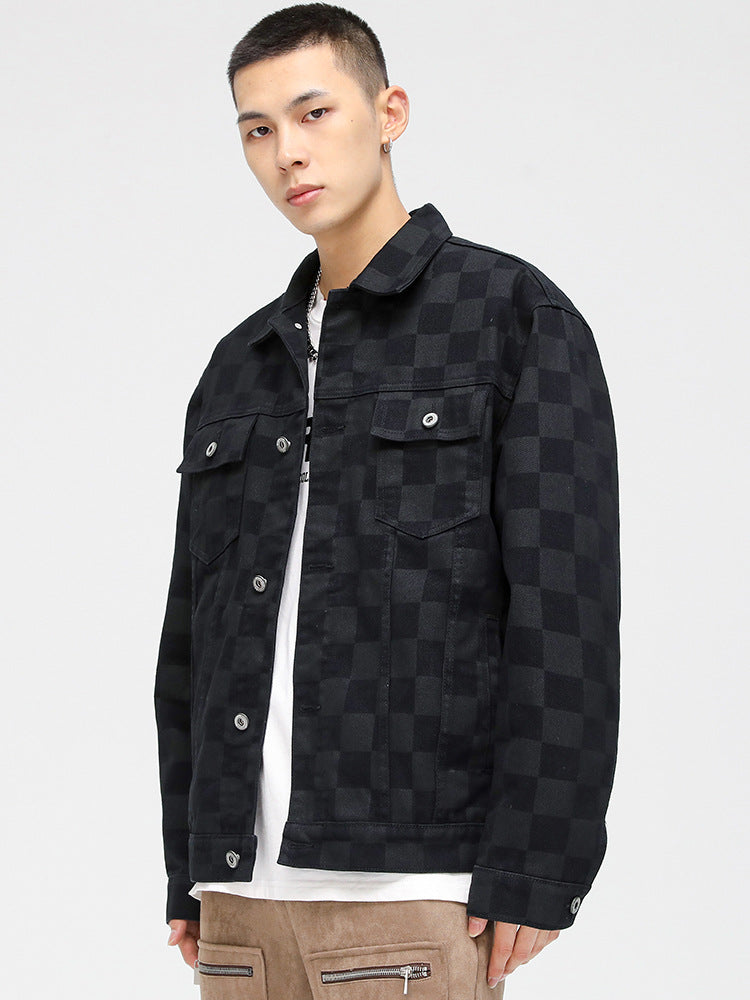 A model is showing the quilted lining of a black checkered jacket over white graphic tee and tan pants against white backdrop