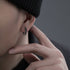 Black silver hoop earring styled on ear with beanie hat
