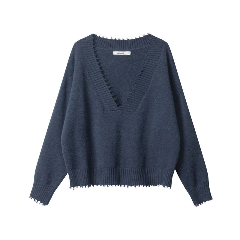 Front view of navy V-neck sweater with simple clean back design, ribbed hem and cuffs with distressed edges.