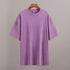 Purple t-shirt on a wooden hanger against a gray background