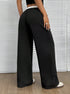 Side view of black palazzo pants with white contrasting waistband and sneakers