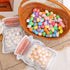 A woven basket filled with colorful Easter eggs, with two transparent jar-shaped bags containing white and golden-speckled eggs nearby.