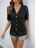 Women wearing a black lace top with decorative buttons and puff sleeves, worn with ripped denim shorts, accessorized with layered gold necklaces.