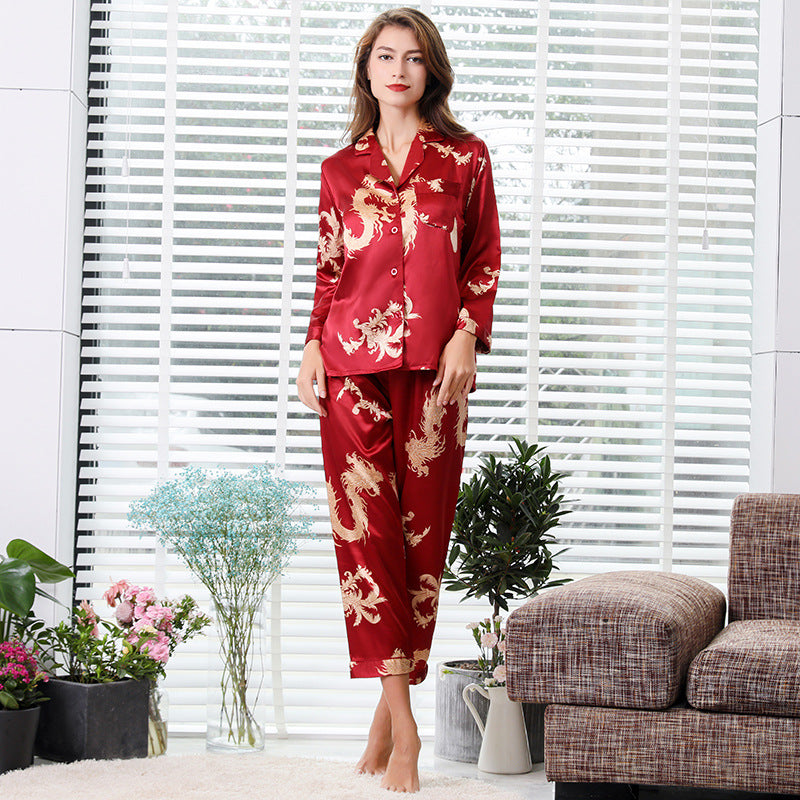 Red silk women's pajama set with golden dragon motif, featuring button-up top and full-length pants for elegant home style