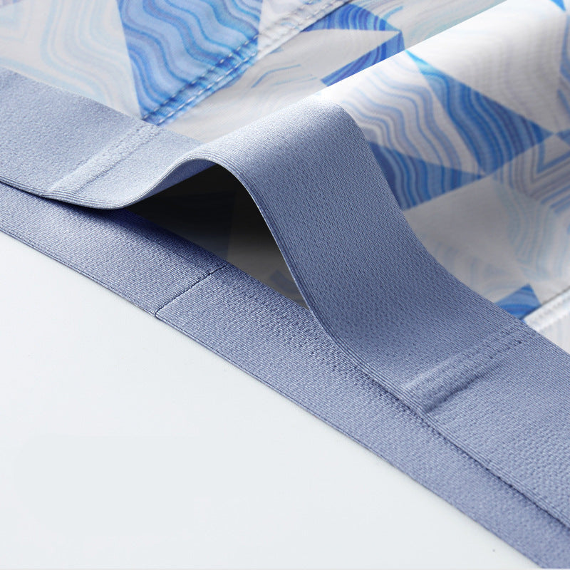 Detail view of blue geometric patterned underwear waistband, highlighting elastic construction and fabric texture