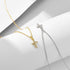 Gold and silver cross pendant necklaces displayed side by side on white geometric surface, both featuring diamond-set crosses