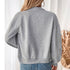Back view of gray bomber jacket with white crop top and blue jeans
