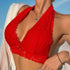 A woman wearing a red lace bralette and white shawl, accessorized with a silver pendant necklace