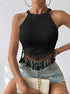 Woman wearing black ribbed halter crop top with lace fringe detail and light denim shorts.