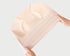 Hands demonstrating stretch of cream-colored seamless brief