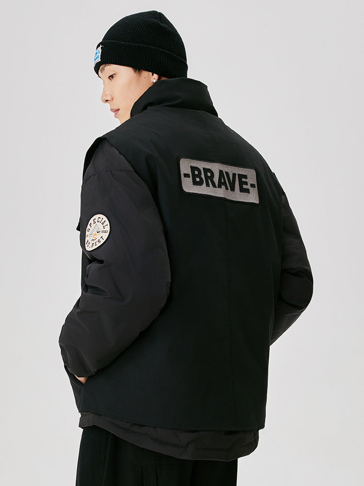 Back view of black utility jacket showing BRAVE text patch and special number badge, styled with black beanie