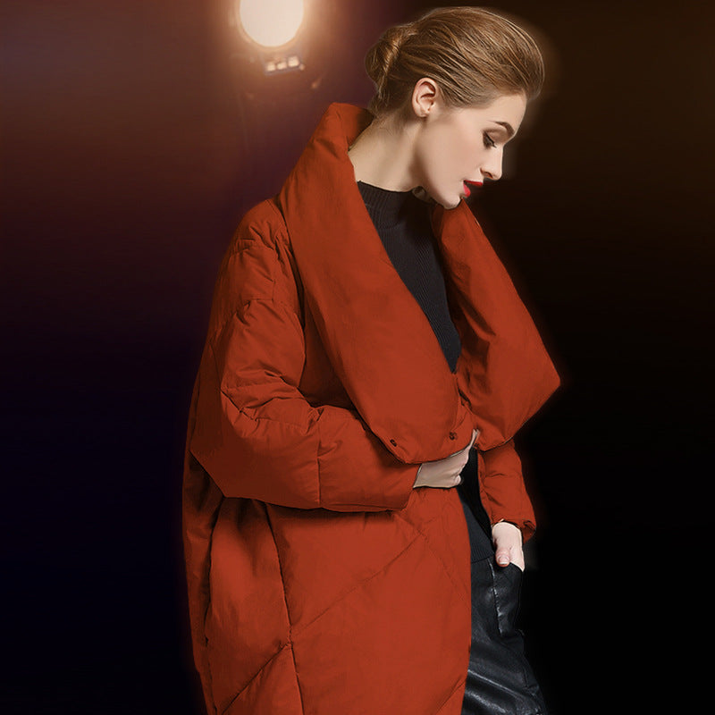 Model in rust-colored puffer coat with dramatic high collar, shown in side profile against dark background