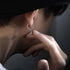 Silver star drop hoop earring being held on ear, artistic side profile shot
