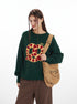 Front view of green knit sweater showing pretzel graphic detail and casual fit