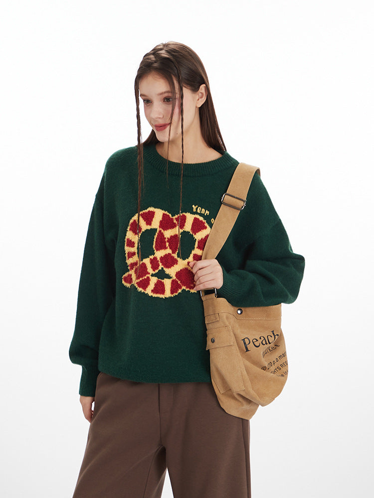 Front view of green knit sweater showing pretzel graphic detail and casual fit
