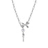 Close-up of silver necklace with central bow charm, purple gemstone in circular setting, and decorative key pendant