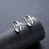 Silver cross hoops with zircon on textured black surface